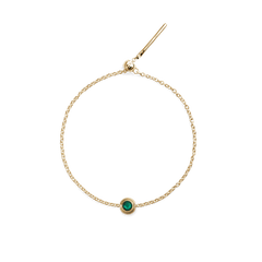 Delicate gold bracelet featuring a central green crystal charm set in a polished gold-coloured stainless steel frame.