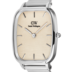 Close-up of the Daniel Wellington Marlon Wire Linen Silver watch, showcasing its cushion-shaped stainless steel case, linen-textured beige dial, minimalist silver hour markers, and sleek crown detail.