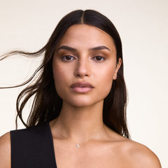A woman wears the Crystal Zodiac Chain Necklace Silver, featuring a sparkling Virgo pendant on a fine silver chain resting elegantly at the collarbone.