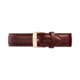 Brown genuine leather watch strap with a tapered design, featuring detailed stitching and a polished rose gold pin buckle engraved with the Daniel Wellington logo. The strap has a smooth finish and quick-release connectors for easy attachment to compatible timepieces.