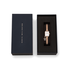 Quadro Mini Crystal Zodiac Melrose Set presented in an elegant black Daniel Wellington gift box, featuring a rose gold women’s watch with a crystal-framed rectangular case, white mother of pearl dial, mesh strap, and sparkling zodiac charm.