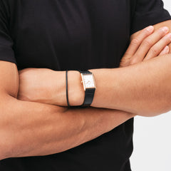A man with arms crossed wears the Bound Black Crocodile Rose Gold watch, featuring a rectangular rose gold case and black crocodile-patterned leather strap, styled with a black T-shirt.