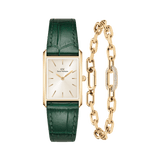 Rectangular gold-tone Daniel Wellington watch with a champagne sunray dial, minimalist gold markers, and a deep green crocodile-embossed leather strap, paired with a matching gold crystal link bracelet featuring a central pavé crystal detail.