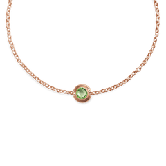 Rose gold chain bracelet featuring a central peridot-coloured crystal charm in a polished stainless steel setting.