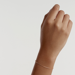 A delicate rose gold box chain bracelet is worn on the wrist, showcasing its slim, minimalist design and subtle shimmer.