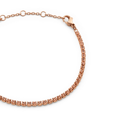 Close-up of the Classic Tennis Bracelet Apricot Rose Gold, showing individually set apricot-coloured Preciosa crystals on a slender rose gold chain with an adjustable lobster clasp.