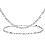 Silver tennis bracelet and matching necklace set, each featuring a continuous row of sparkling crystals in a refined silver finish, showcasing a timeless and elegant jewellery design.