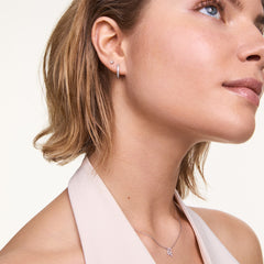 A woman wears the Crystal Hoop + Stud Silver Set, featuring a crystal-embellished silver hoop and a delicate crystal stud in double piercings, styled for an elegant and modern look.