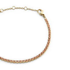 Close-up of the Classic Tennis Bracelet Apricot Gold, showing individually set apricot Preciosa crystals in a slim gold-plated chain with an adjustable clasp.