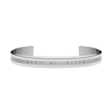 Minimalist Daniel Wellington Elan Bracelet in polished silver stainless steel, featuring a curved open cuff design with a brushed centre and engraved branding.