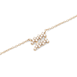 Close-up of a gold chain necklace featuring a zodiac pendant encrusted with sparkling hand-set crystals.
