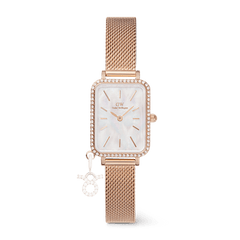 Rose gold rectangular women’s watch with a sparkling crystal bezel, mother of pearl dial, and a mesh strap featuring a detachable zodiac charm.