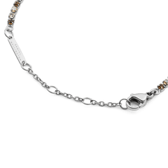 Detail view of the Classic Tennis Bracelet Honey Combo Silver, highlighting the adjustable silver chain, secure lobster clasp, and Daniel Wellington engraved tag.