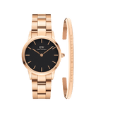 Rose gold Daniel Wellington watch with a black dial and matching rose gold link strap, paired with a slim rose gold bracelet engraved with subtle branding, both crafted in stainless steel for a coordinated and elegant look.