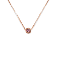 Rose gold necklace featuring a delicate chain and a central charm set with a faceted pink crystal.
