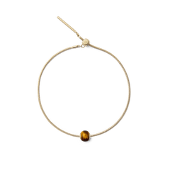 Gold snake chain bracelet featuring a polished tiger eye orb charm with natural golden-brown tones, offering a refined and versatile accent for everyday wear.