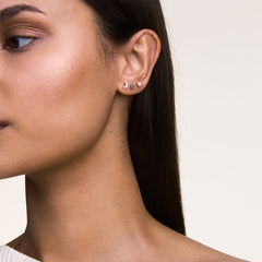 Woman wearing the Crystal Moon + Flower + Heart Rose Gold Set, featuring three dainty rose gold stud earrings in moon, flower, and heart shapes, styled together on one ear for a refined, modern look.