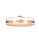 Rose gold bracelet set featuring a sleek cuff with engraved Daniel Wellington branding and a delicate chain bracelet, both designed for a refined, minimalist look.