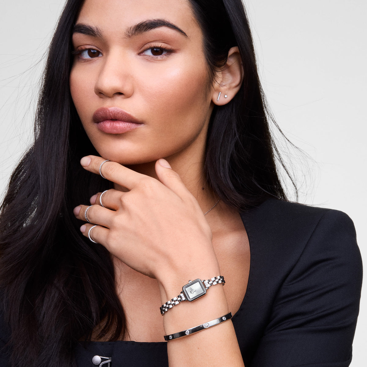 Woman wearing the Classic Lumine Bracelet Silver 5.5mm on her wrist, styled alongside a silver watch and minimalist rings, showcasing the bracelet’s polished silver finish and sparkling cubic zirconia crystals for an elegant, modern look.
