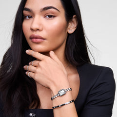 Woman wearing the Classic Lumine Bracelet Silver 5.5mm on her wrist, styled alongside a silver watch and minimalist rings, showcasing the bracelet’s polished silver finish and sparkling cubic zirconia crystals for an elegant, modern look.