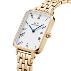 Daniel Wellington Quadro Roman Numerals 5-Link Gold watch with rectangular white dial, blue hands, and gold bracelet strap.