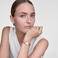 Woman wearing Audrey Ring in rose gold with mother of pearl, styled with matching bracelet, earrings and watch.