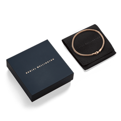 Tide Mesh Bracelet Melrose 2.8 in rose gold displayed on a black pouch beside a sleek Daniel Wellington gift box.