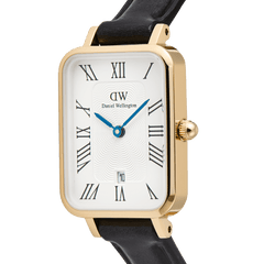 Close-up of the Quadro Roman Numerals Date Sheffield Gold watch, highlighting its rectangular gold-plated case, white dial with Roman numerals, blue hands, date window, and black leather strap.