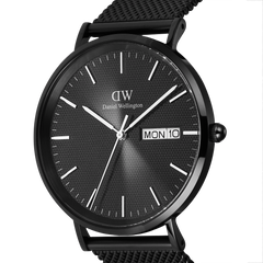 Close-up of the Daniel Wellington Classic Day Display Onyx watch, featuring a textured black dial with day and date display, slim silver hour markers, and a polished black stainless steel case.