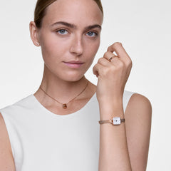 A woman wears the Elan Necklace Rose Gold featuring a minimalist ring pendant on a delicate rose gold chain, styled with a matching watch and ring for an elegant, modern look.