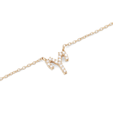 Close-up of a gold zodiac chain necklace featuring a sparkling crystal-encrusted pendant in a claw setting.