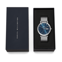 Daniel Wellington Classic Day Display Sterling Arctic watch with a blue dial and silver mesh strap, presented in an elegant branded gift box.