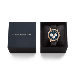 Iconic Chronograph Sheffield Arctic Panda Rose Gold watch by Daniel Wellington presented in an elegant black gift box, showcasing its blue dial, white sub-dials, rose gold case, and black leather strap.