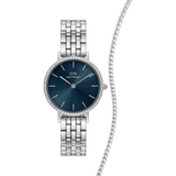 Silver Daniel Wellington women’s watch with a deep blue dial and sparkling bezel, paired with a slender tennis bracelet adorned with shimmering stones.