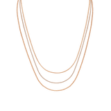 Three gold box chain necklaces of varying lengths are layered together, showcasing a refined and elegant design with a radiant finish.