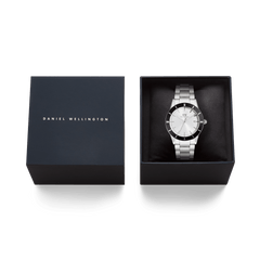 Iconic Paradigma Link Black Bezel men’s watch with a silver dial and black aluminium bezel, presented in an elegant Daniel Wellington gift box.