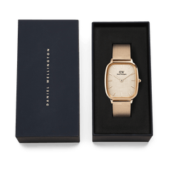 Daniel Wellington Marlon Melrose Linen watch with a rose gold mesh strap and linen-textured dial, elegantly presented in a navy gift box with gold branding.