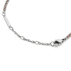 Detail view of the Classic Tennis Bracelet Apricot Silver, showing the adjustable silver chain, secure lobster clasp, and Daniel Wellington logo tag alongside apricot-coloured crystals.