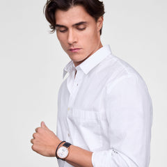 A man wearing the Classic Multi-Eye Sheffield Off-white Sunray Rose Gold watch, featuring a rose gold case, off-white dial with blue sub-second hand, and a black leather strap, styled with a crisp white shirt for a refined look.