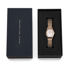 Ophelia Mini Rose Gold women’s watch with an oval case and polished rose gold bracelet, elegantly presented in a black Daniel Wellington gift box.