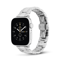 Silver Daniel Wellington Smartwatch Iconic Link strap attached to an Apple Watch, featuring a classic three-link stainless steel design with a brushed and polished finish, butterfly clasp, and a comfortable tapered fit.