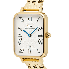 Close-up of the Daniel Wellington Quadro Roman Numerals Date 5-link Gold watch, showing the rectangular gold case, white guilloché dial with black Roman numerals, blue hands, and a date window at 6 o’clock.