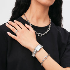 Woman wearing the Crystal Link Ring Silver on her hand, styled with a matching chunky chain necklace and bracelet, along with a silver watch, showcasing a coordinated and contemporary jewellery look.