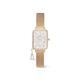 Elegant women's gold watch featuring a rectangular case with a crystal-set bezel, white mother of pearl dial, gold mesh strap, and an interchangeable crystal zodiac charm attached to the bracelet.