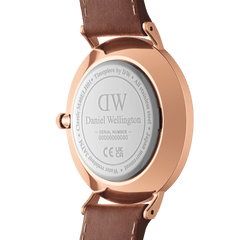 Back view of the Classic Multi-Eye St Mawes Amber Rose Gold watch showing the engraved Daniel Wellington logo, stainless steel case, and brown leather strap.