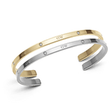 Set of two Daniel Wellington open cuff bracelets in polished silver and gold tones, each featuring subtle crystal accents and the signature DW engraving, designed for a refined and versatile look.