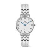 Silver Daniel Wellington women’s watch with a round white dial, bold Roman numerals, blue hands, date window at 6 o’clock, and a polished 5-link stainless steel strap. The guilloché inner pattern and butterfly clasp add refined detail and comfort.