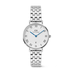 Silver Daniel Wellington women’s watch with a round white dial, bold Roman numerals, blue hands, date window at 6 o’clock, and a polished 5-link stainless steel strap. The guilloché inner pattern and butterfly clasp add refined detail and comfort.