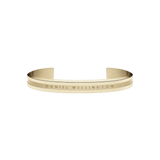 Polished gold-tone Daniel Wellington Elan Bracelet featuring a minimalist open cuff design with engraved branding and a smooth, refined finish.