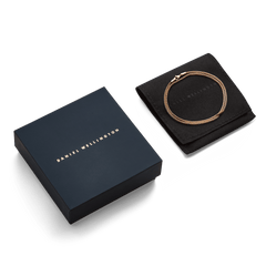 Tide Mesh Necklace Rose Gold 1.8 presented on a black protective pouch next to a sleek Daniel Wellington gift box, highlighting its elegant packaging and refined rose gold mesh chain.